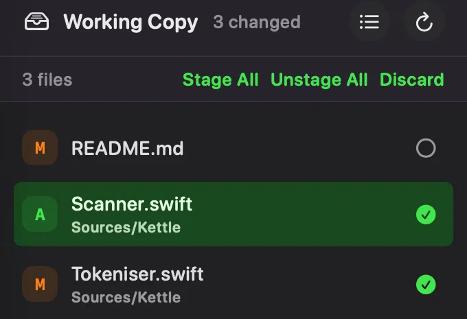 The working copy file list after staging a file: README.md marked M with an empty circle at the end of its row, Scanner.swift marked A with a green tick, and Tokeniser.swift marked M with a green tick